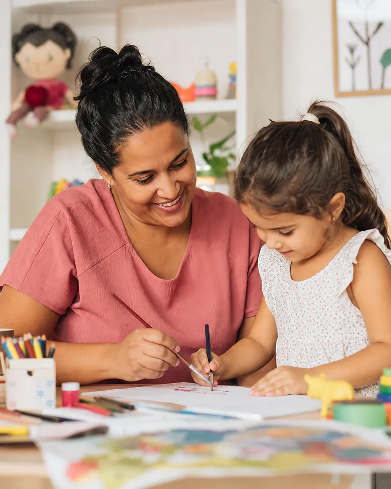 Babá interagindo com uma criança durante uma atividade educativa